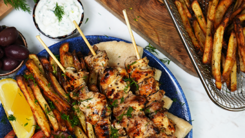 Which herbs enhance the flavor of Greek souvlaki?