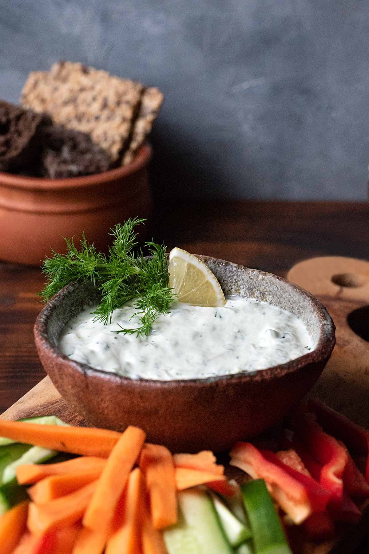 Why is yogurt used in many Greek marinades and dips?